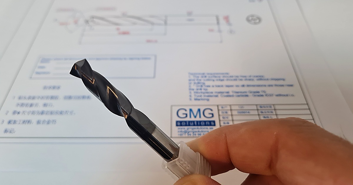 A GMG Private Label carbide drill held next to its GMG Solutions technical drawing