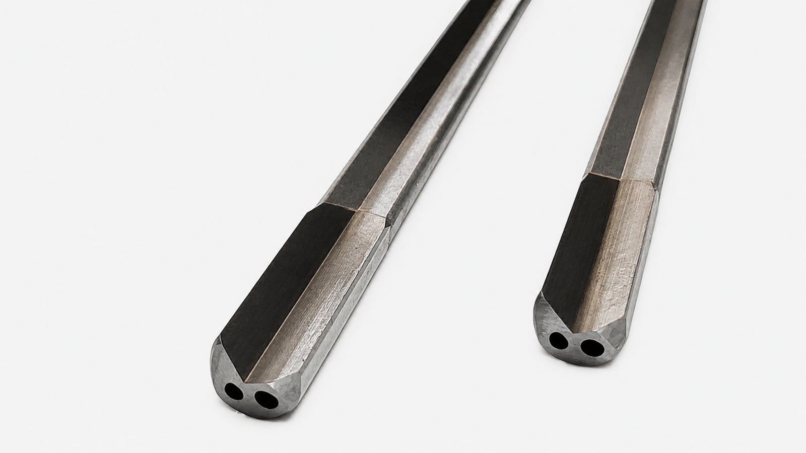 Close-up of two single-flute gundrills showing their angled cutting tips and coolant holes